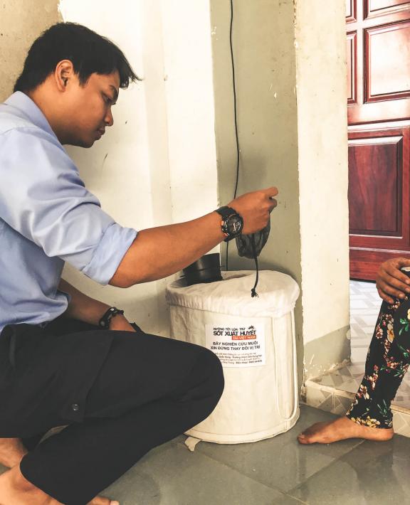 setting up a mosquito trap at a host home