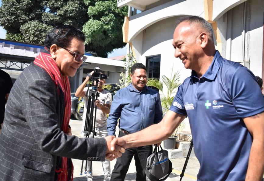 The Minister of Health of Timor-Leste meeting a World Mosquito Program volunteer. Camera in background. 